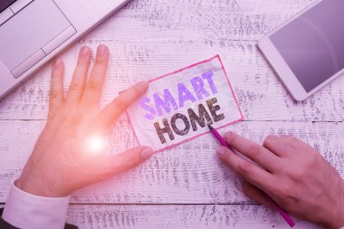 Smart Home 'a mesaj yazıyorum. Otomasyon sistemi denetimi için iş konsepti iklim eğlence sistemlerini ışıklandırmak için yazma ekipmanı ve modern akıllı telefon aygıtının yanında el kağıdı tutun.