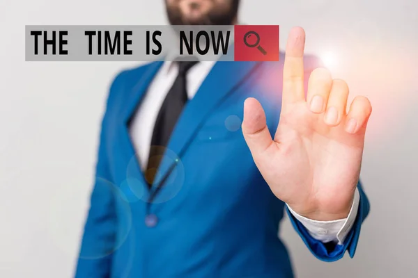 Text sign showing The Time Is Now. Conceptual photo encouraging someone to start doing today Dont be late Businessman with pointing finger in front of him.