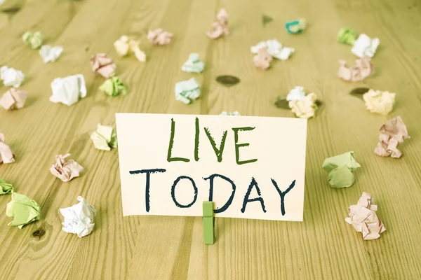 Conceptual hand writing showing Live Today. Business photo text spend your life doing what you want Live in the present moment Colored crumpled papers wooden floor background clothespin.