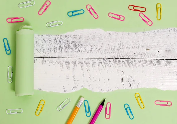 Cartón rasgado con clip de papel colocado encima de una mesa clásica de madera. Papel grueso desgarrado y fijo sobre un fondo de madera texturizada. Manera artística de organizar planos pone fotografía — Foto de Stock