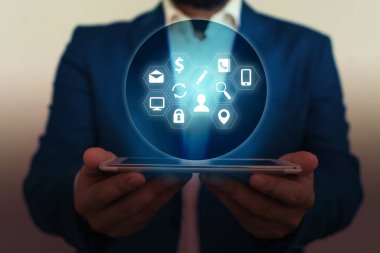 Erkek insan en son gelişmiş cihazları kullanarak sunum yapıyor. Adam, akıllı aletlerin nasıl çalıştığını gösteren resmi bir takım elbise giyiyor. Modern hayatın fotoğrafı..