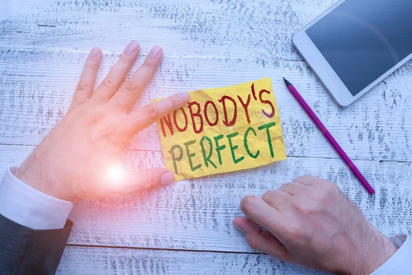 Handwriting text Nobody S Is Perfect. Concept meaning used to say that everyone makes mistakes or fault Hand hold note paper near writing equipment and modern smartphone device. — Stock Photo, Image