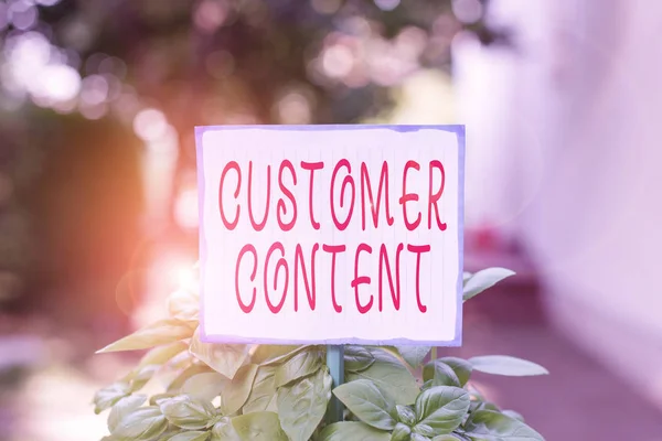 Writing note showing Customer Content. Business photo showcasing content created voluntarily by customers and share publicly Plain paper attached to stick and placed in the grassy land.