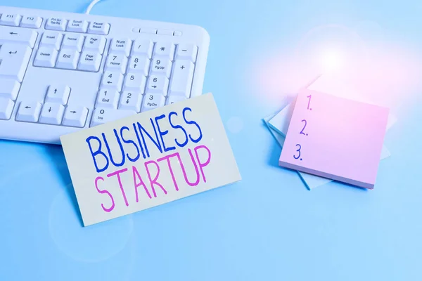 Text sign showing Business Startup. Conceptual photo company that is in the first stage of its operations Paper blue desk computer keyboard office study notebook chart numbers memo. — Stock Photo, Image