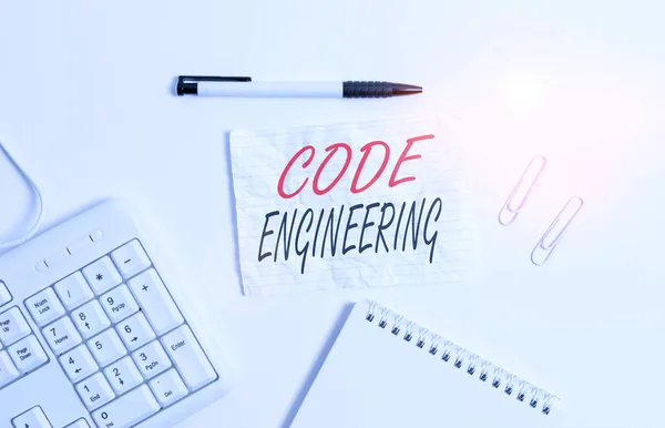 Text sign showing Code Engineering. Conceptual photo application of engineering to the development of software White pc keyboard with empty note paper and pencil above white background.