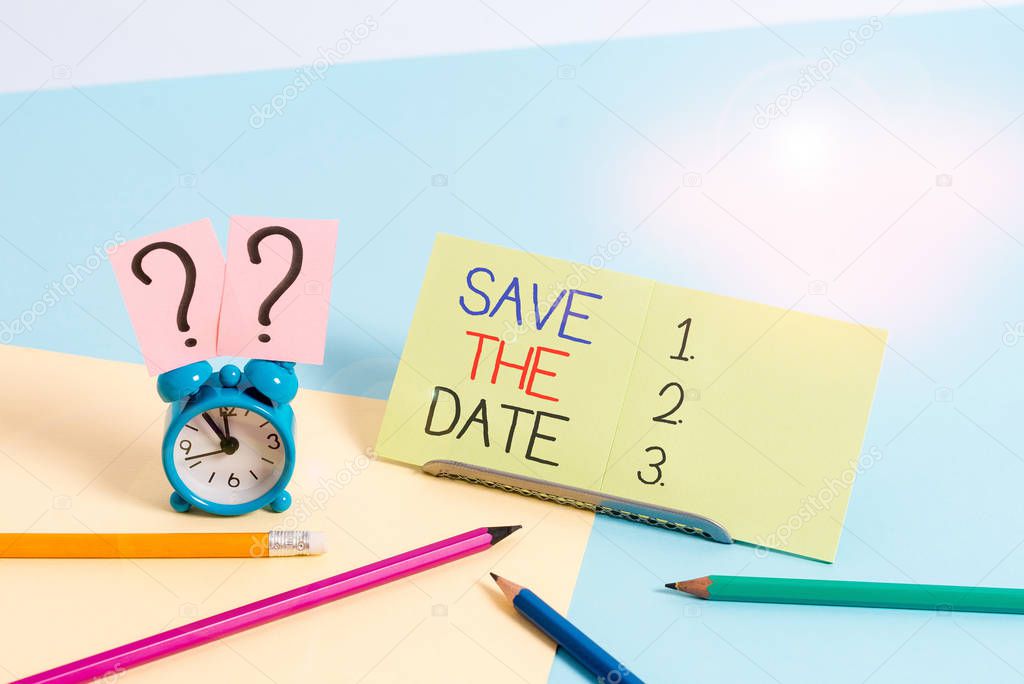 Text sign showing Save The Date. Conceptual photo Systematized events Scheduled activity Recorded Filed Mini size alarm clock beside stationary placed tilted on pastel backdrop.