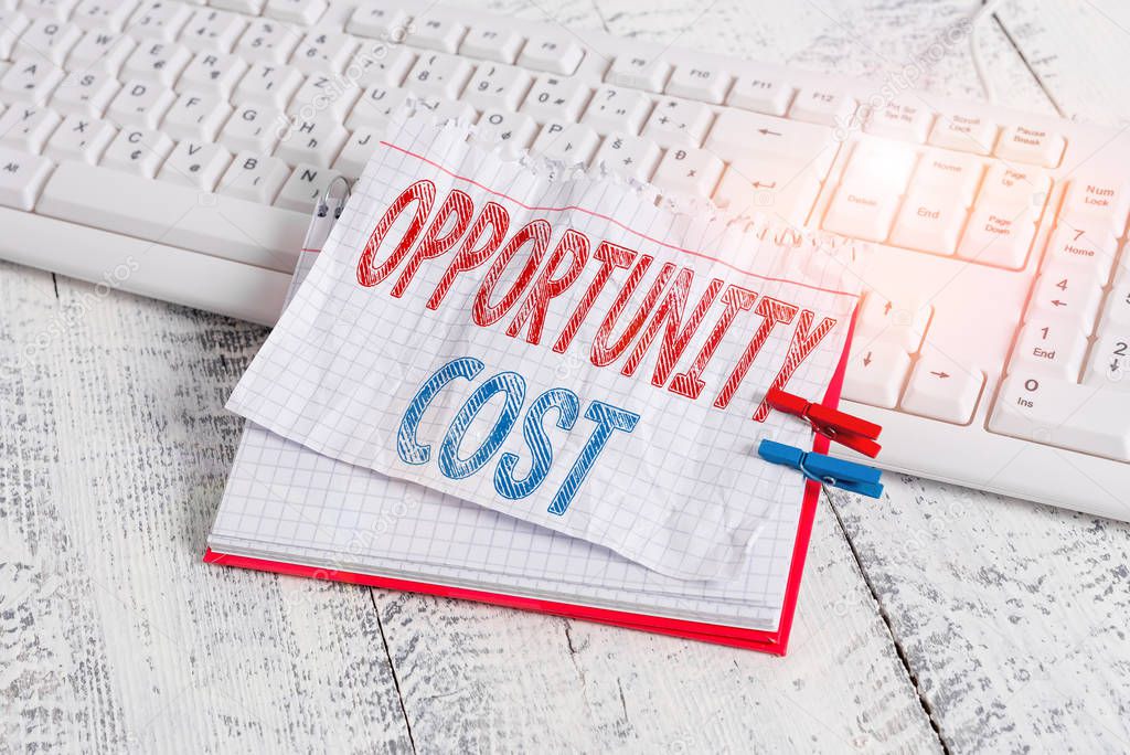 Text sign showing Opportunity Cost. Conceptual photo the price of the next best thing you could have done notebook paper reminder clothespin pinned sheet white keyboard light wooden.