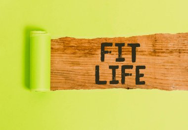 Sözcük yazarlığı Hayata Uygun. Sağlıklı beslenme ve egzersiz ile sağlıklı bir ağırlığı korumak için iş konsepti ortadan ikiye bölünmüş sağlıklı yaşayan karton klasik ahşap bir masanın üzerine yerleştirilmiş.