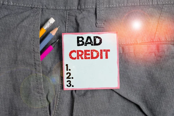 Writing note showing Bad Credit. Business photo showcasing inability of a demonstrating or company to repay a debt on time Writing equipment and blue note paper in pocket of trousers. — Stock Photo, Image