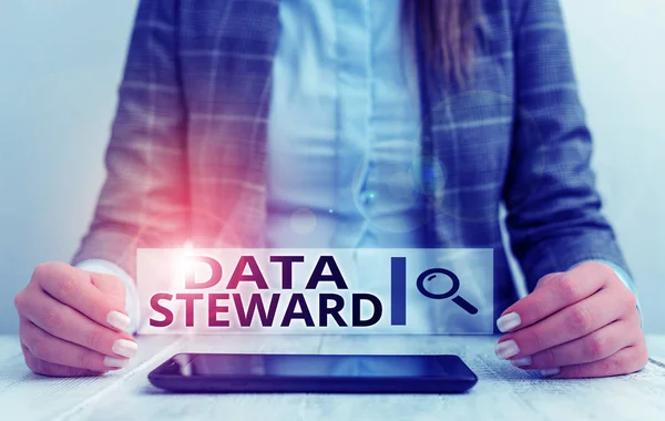Handwriting text writing Data Steward. Concept meaning responsible for utilizing an organization s is data governance Business woman sitting with mobile phone on the table.