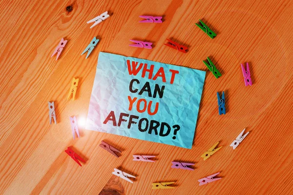 Word writing text What Can You Afford Question. Business concept for Give us your budget availability of money Colored clothespin papers empty reminder wooden floor background office.