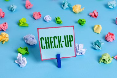 Kelime yazma metni Check Up. Fiziksel tıbbi veya klinik muayene için iş konsepti inceleyerek yapılan Renkli buruşuk kağıtları boş hatırlatma mavi zemin arka plan clothespin.