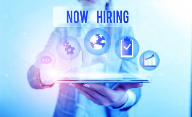 Kavramsal el yazısı Now Hiring 'i gösteriyor. Yeni yetenekler arayan bazı şirketlerin resmi iş kıyafetlerini giydiğini açıklayan bir iş fotoğrafı sergisi..