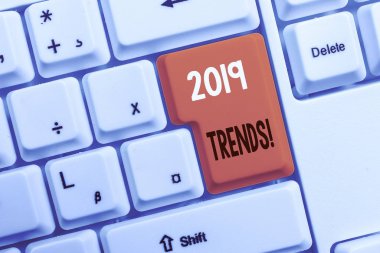 2019 Trendlerini gösteren metin işareti. Bir şeyin beyaz arka plan tuşu kopyalama alanının üzerinde boş not kağıdıyla beyaz bilgisayar klavyesi geliştirdiği veya değiştirdiği kavramsal fotoğraf genel yönü.