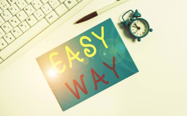 Easy Way 'i gösteren bir not yazıyorum. İş fotoğrafı gösterimi, gittikçe daha az çaba gerektiren iki yöntem arasındaki zor kararı verirken bilgisayar klavyesi ve saatinde boş not kağıdının üzerinde duruyordu..