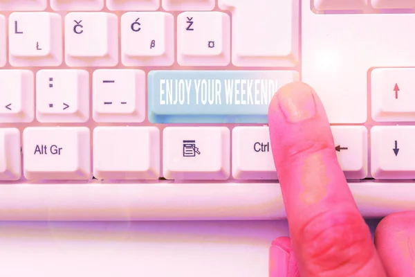 Writing note showing Enjoy Your Weekend. Business photo showcasing wishing someone that something nice will happen at holiday White pc keyboard with note paper above the white background.