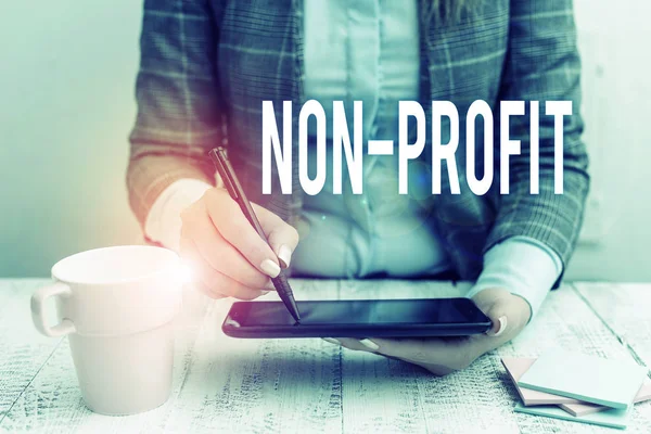 Schreiben Notiz zeigt Non-Profit. Business-Foto präsentiert Bereitstellung von Produkten oder Dienstleistungen ohne Rückzahlung Geschäftsfrau sitzt mit Handy und Tasse Kaffee auf dem Tisch. — Stockfoto