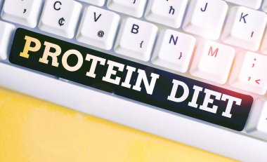 Protein diyetini gösteren bir not yazıyorum. İş fotoğraflarında düşük yağ ya da karbonhidrat tüketim zayıflama planı beyaz arka planda notalı beyaz pc klavye.