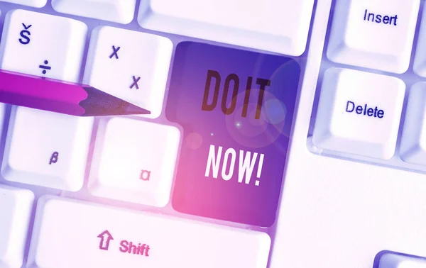 Handwriting text Do It Now. Concept meaning not hesitate and start working or doing stuff right away White pc keyboard with empty note paper above white background key copy space.