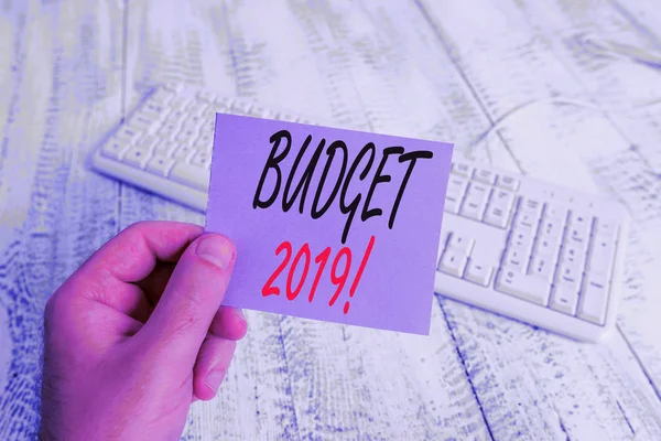 Szöveges jel mutatja költségvetés 2019. Koncepcionális fotó becslés bevételi és kiadási az adott évben az ember gazdaság színes emlékeztető négyzet alakú papír fehér billentyűzet fa padló. — Stock Fotó