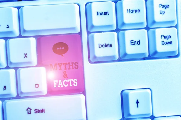 Text sign showing Myths And Facts. Conceptual photo usually traditional story of ostensibly historical events White pc keyboard with empty note paper above white background key copy space.