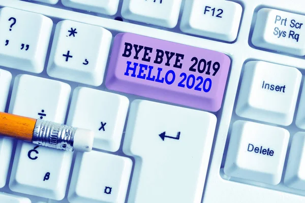 Texto de escritura de palabras Bye Bye 2019 Hello 2020 Concepto de negocio para iniciar un nuevo año El mensaje motivacional 2019 ha terminado Teclado de PC blanco con papel de nota vacío sobre el espacio de copia de clave de fondo blanco . —  Fotos de Stock