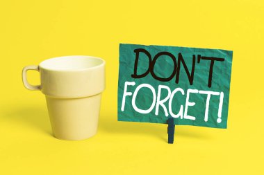 El yazısı metin Don T Forget. Kavram anlamı önemli gerçeği veya detay Hakkında birisi hatırlatmak için kullanılan Fincan boş kağıt mavi clothespin dikdörtgen şekilli hatırlatma sarı ofis.