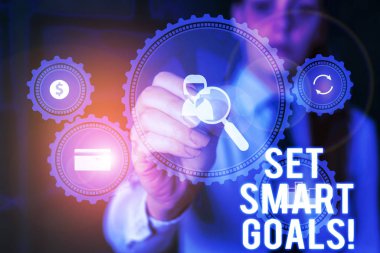 Word writing text Set Smart Goals. Business concept for list to clarify your ideas focus efforts use time wisely Woman wear formal work suit presenting presentation using smart device.