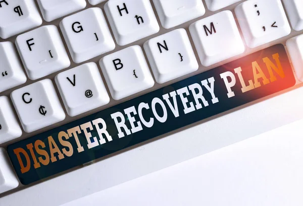 Text sign showing Disaster Recovery Plan. Conceptual photo having backup measures against dangerous situation White pc keyboard with empty note paper above white background key copy space.