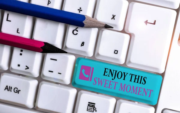 Word writing text Enjoy This Sweet Moment. Business concept for encouraging someone to love his life timeline White pc keyboard with empty note paper above white background key copy space.