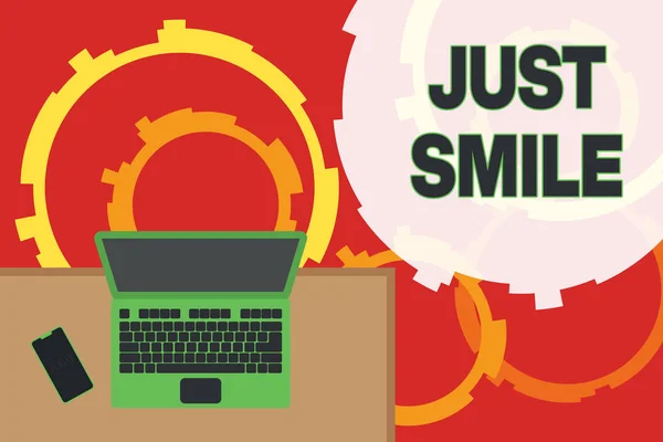 Escribiendo nota mostrando Just Smile. Exhibición de fotos de negocios asumen una expresión facial que indica placer o diversión Oficina lugar de trabajo portátil tumbado escritorio de madera smartphone . —  Fotos de Stock