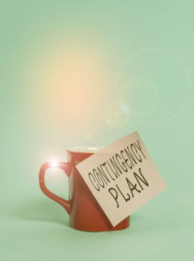 Text sign showing Contingency Plan. Conceptual photo A plan designed to take account of a possible future event Coffee tea cup mug colored sticky note lying beautiful pastel background.