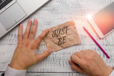 Just Be 'yi gösteren bir not yazıyorum. İnandığınız şeyleri yapabilmek için iş fotoğraflarınızı sergilemek ve yazma ekipmanı ve akıllı telefonun yanında el yazısı kağıdı bulundurmak için kabul edilmek..