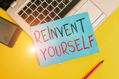 Kendini yeniden keşfettiğini gösteren bir not yazıyorum. İş fotoğrafı gösterimi davranışı değiştirmek için farklı bir şey yapmak için Metalik dizüstü bilgisayar küçük kağıt sayfa kalem akıllı telefon renkli arkaplan.