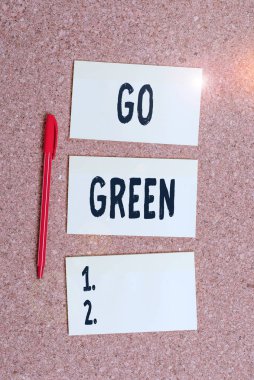 Go Green 'i gösteren kavramsal el yazısı. İş fotoğrafı gösterimi, geri dönüşüm için daha çevre dostu kararlar veriyor. Boş etiketi hatırlatan not pano mantar masa kağıdı..