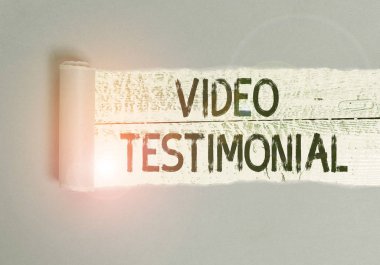 Video Tanıklığını gösteren bir not yazıyorum. İş fotoğrafında, tahtadan yapılmış klasik bir masanın üzerine yerleştirilmiş olan video kartondan elde edilen faydalara tanıklık eden bir ifade gösteriliyor..