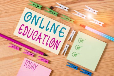 Çevrimiçi Eğitimi gösteren kavramsal el yazısı. İnternet üzerinden gerçekleşen iş fotoğrafı gösterimi türünde bir öğrenme. Renkli buruşuk kağıtlar. Ahşap zemin mandalı..