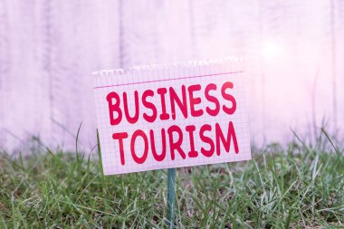 İş Turizmini gösteren kavramsal el yazısı. Ticari amaçla bırakılan iş metni etkinliği, bir sopaya bağlanmış ve çimenli topraklara yerleştirilmiş matematik kağıdı için doğal bir yerdir..