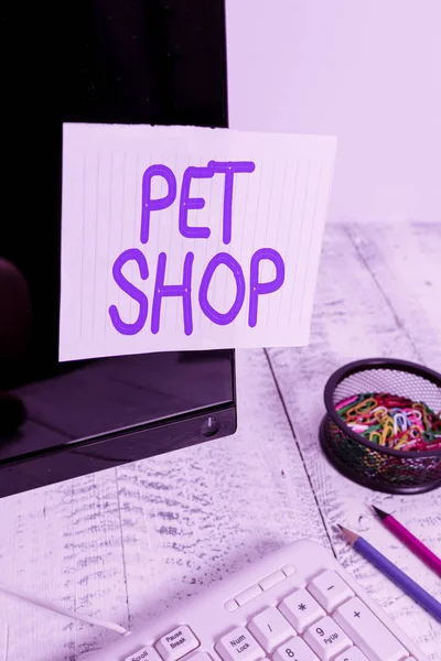 Conceptual hand writing showing Pet Shop. Business photo text Retail business that sells different kinds of animals to the public Note paper taped to black screen near keyboard stationary. — 图库照片