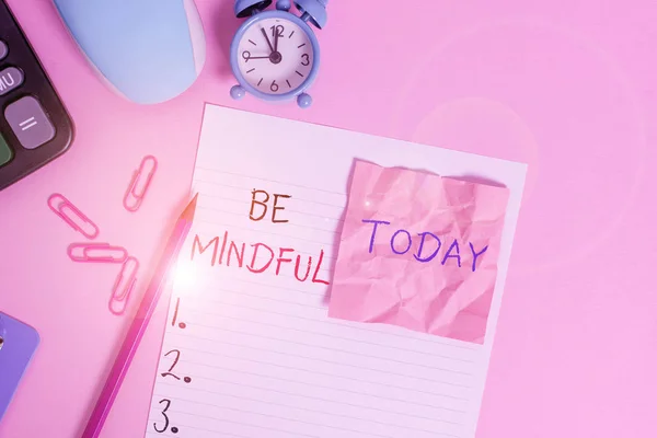 Text sign showing Be Mindful. Conceptual photo paying close attention to or being conscious of something Calculator clips clock clipboard mouse sheet note pencil color background.