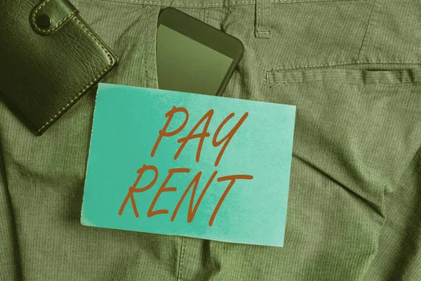 Conceptual hand writing showing Pay Rent. Business photo text To pay money in exchange for the use of someone else s is property Smartphone device inside trousers front pocket with wallet.