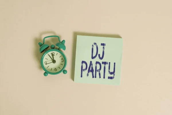 Writing note showing Dj Party. Business photo showcasing demonstrating who introduces and plays recorded popular music on radio Vintage alarm clock wakeup blank notepad sticky note colored background. — ストック写真