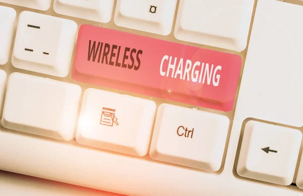 Conceptual hand writing showing Wireless Charging. Business photo showcasing methods of charging batteries without the use of cables White pc keyboard with note paper above the white background. — Stockfoto