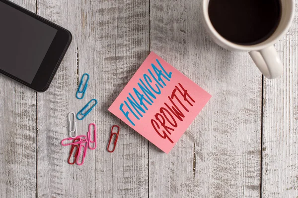 Tekstbord met financiële groei. Conceptuele foto verhoging van de financiën van een organisatie of individuele Stationair geplaatst naast een kopje zwarte koffie boven de houten tafel. — Stockfoto