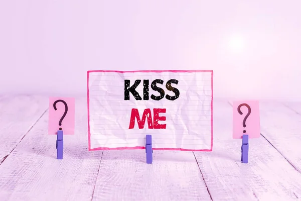 Handschrift sms 'je Kiss Me. Concept betekent informeel verzoek om mijn lippen aan te raken met je lippen of druk tegen gekruld en afbrokkelend vel met paperclips geplaatst op de houten tafel. — Stockfoto