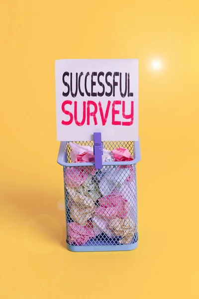 Conceptual hand writing showing Successful Survey. Business photo text measure of opinions or experiences of a group of showing Trash bin crumpled paper clothespin office supplies yellow.