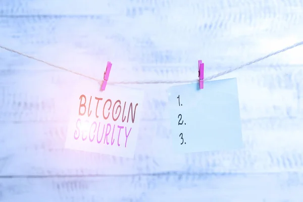 Text sign showing Bitcoin Security. Conceptual photo funds are locked in a public key cryptography system Clothesline clothespin rectangle shaped paper reminder white wood desk.