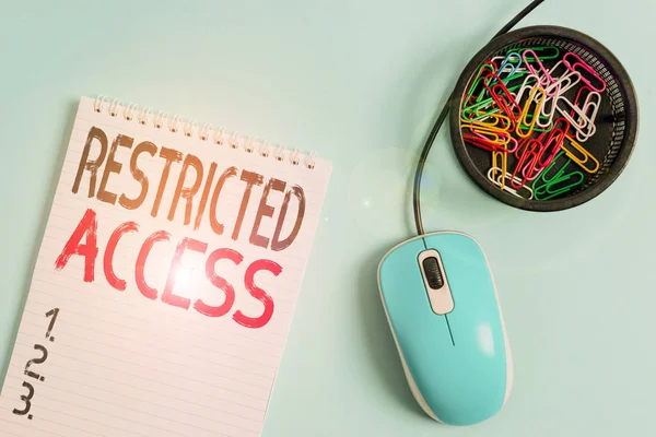 Word writing text restricted access. Geschäftskonzept für eine Dienstleistungsklasse, in der Benutzern der Zugriff auf leere Notebooks und Clips mit Computermaus über pastellfarbenem Hintergrund verwehrt werden kann. — Stockfoto