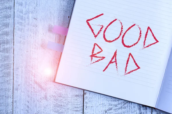 Writing note showing Good Bad. Business photo showcasing to seem to be going to have a good or bad result Life choices Notebook stationary placed above classic wooden backdrop.