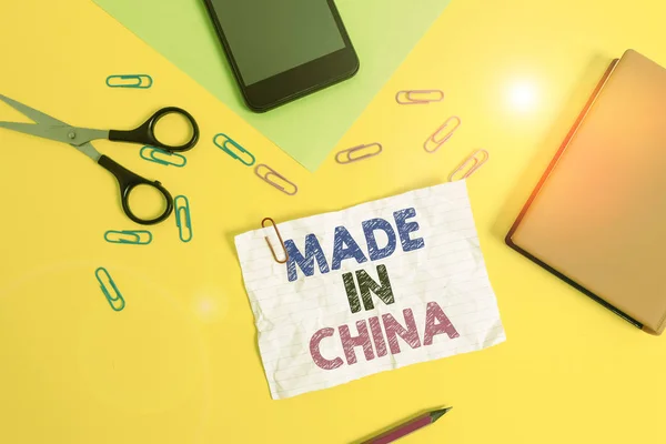 Text sign showing Made In China. Conceptual photo Wholesale Industry Marketplace Global Trade Asian Commerce Paper sheets pencil clips smartphone scissors notebook colored background. — 图库照片